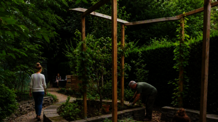Bewoners onderhouden samen een gemeenschappelijke tuin bij een woongroep.